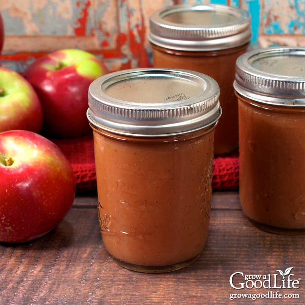 Jars of home canned apple butter on a table.