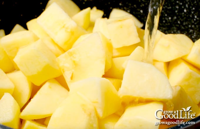 Peeled apple chunks in a large saucepot.