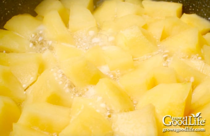 Overhead view of apples cooking in a large pot.