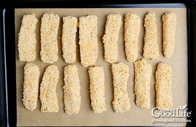 breaded fish sticks on a baking sheet