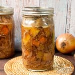 Jars of home canned beef pot roast on a table.