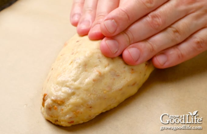 Shaping the dough with wet fingers into a log shape.