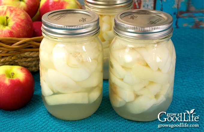 jars of canned apples on a blue towel