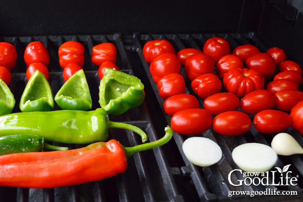 Tomatoes, peppers, and onions on a gas grill.