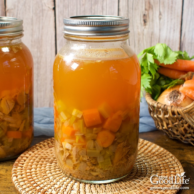 Jars of home canned turkey soup on a table.