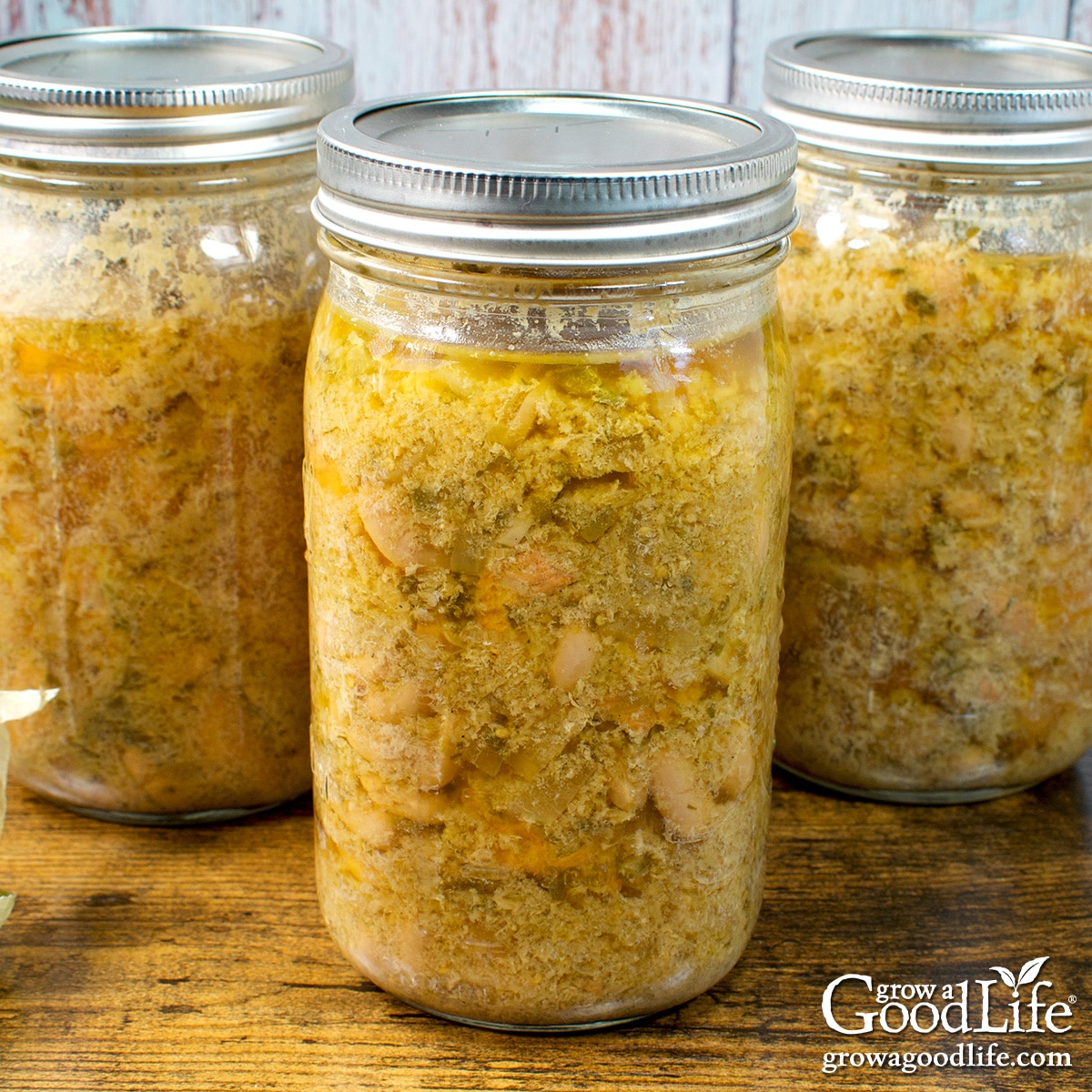 Jars of home canned chicken chili verde on a table.