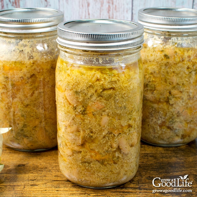 Jars of home canned chicken chili verde on a table.