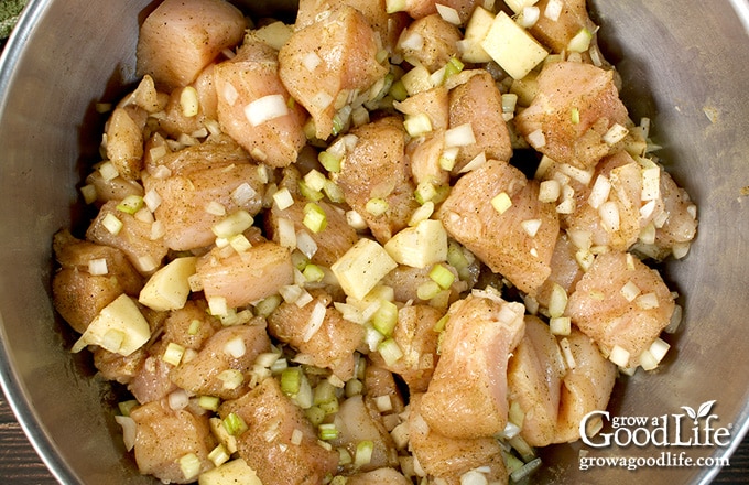 Large prep bowl of prepared ingredients for canning chicken and gravy in a jar.