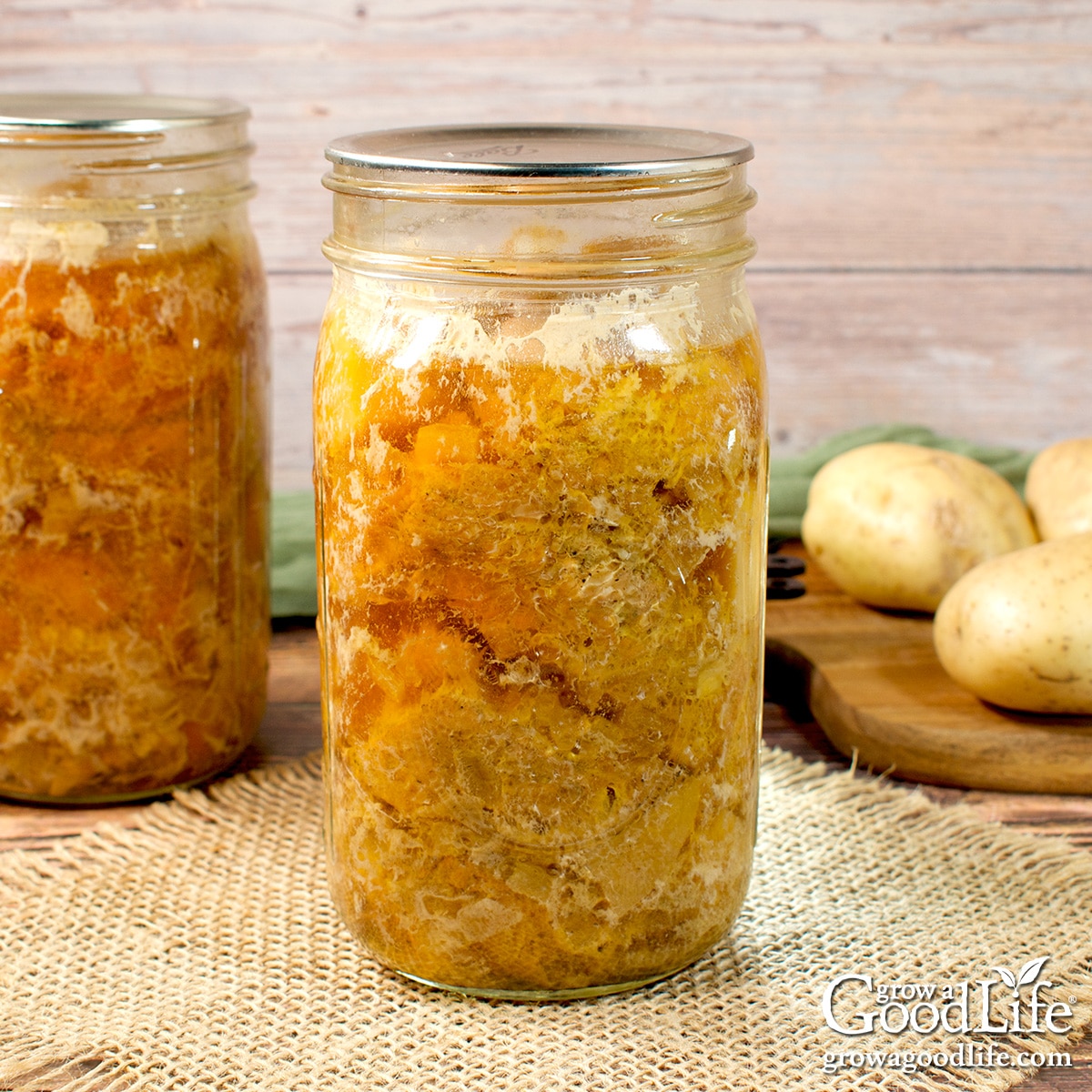 Jars of home canned chicken and gravy on a table.