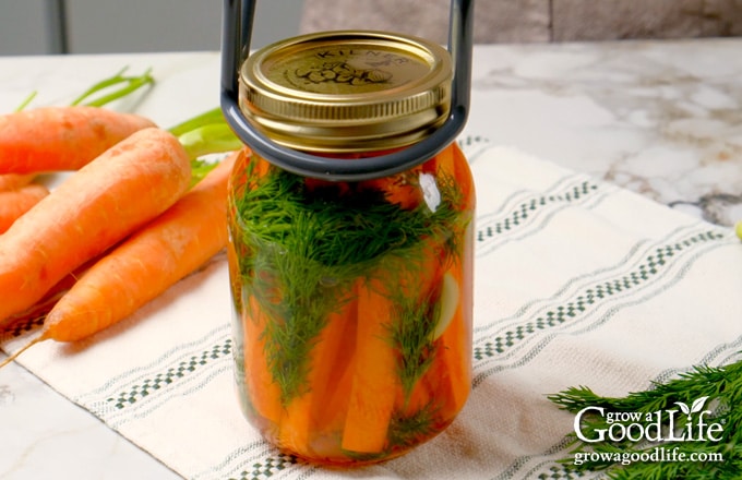 Removing a hot jar from the canner and placing it on a towel.