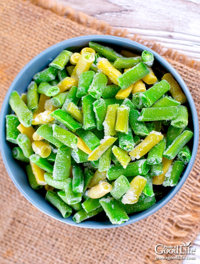 blue bowl of frozen string beans on a table