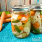 jars of giardiniera pickled vegetables on a blue towel