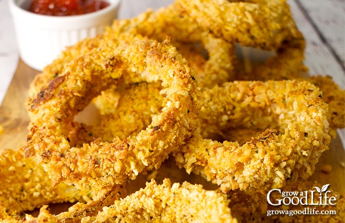 closeup of a pile of baked onion rings on a board