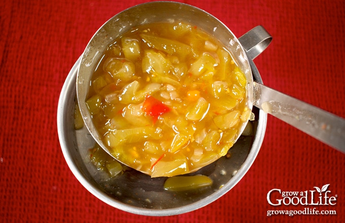 Overhead image of filling a jar with piccalilli.