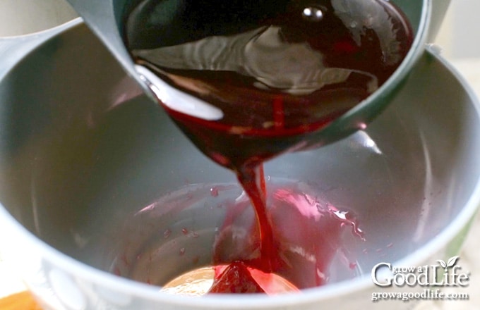 Ladling hot brine over beets in the jar.