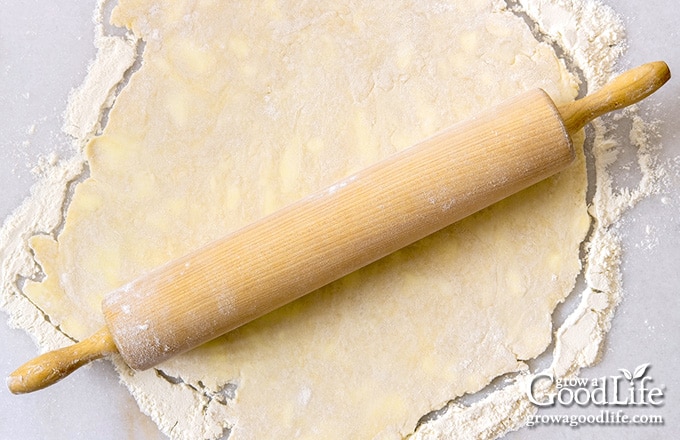 rolling pie crust on a white table