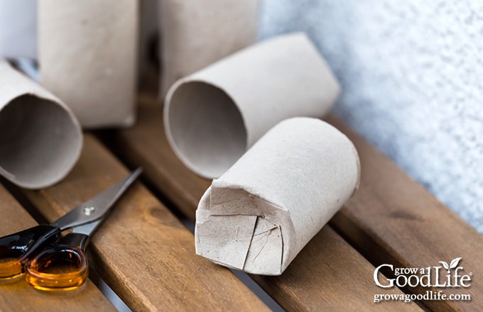 close up of folding the bottom of a cardboard tube