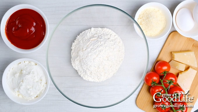 Bowl of flour surrounded by bowls of ingredients in recipe