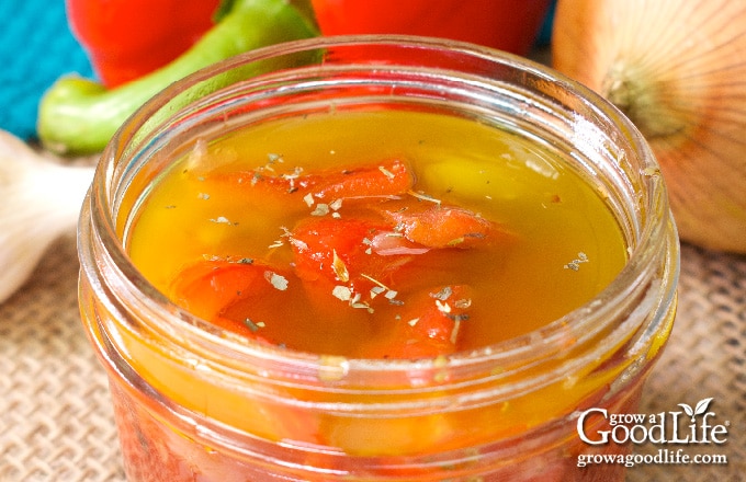 overhead closeup photo of marinated red peppers in a jar