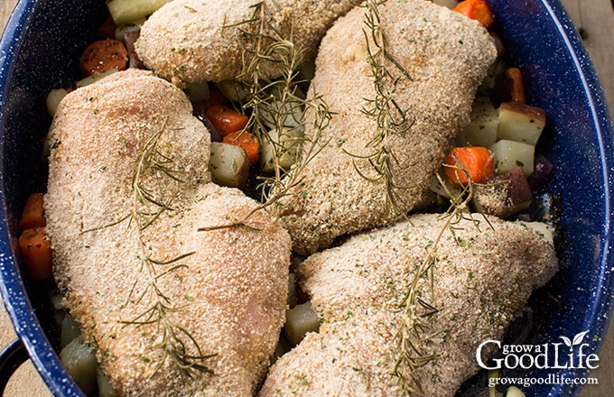 breaded chicken on top of the vegetables in the roasting pan