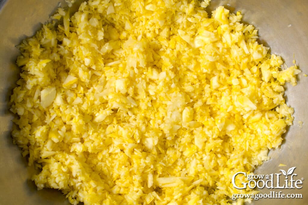 Close up of prepared summer squash and onion in a large prep bowl.