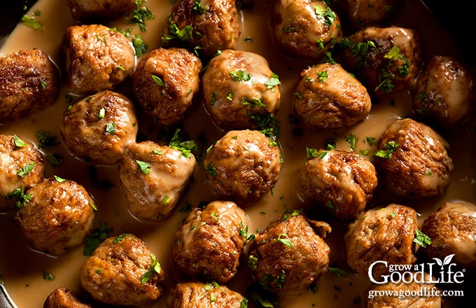 overhead image of meatballs simmering in cream sauce