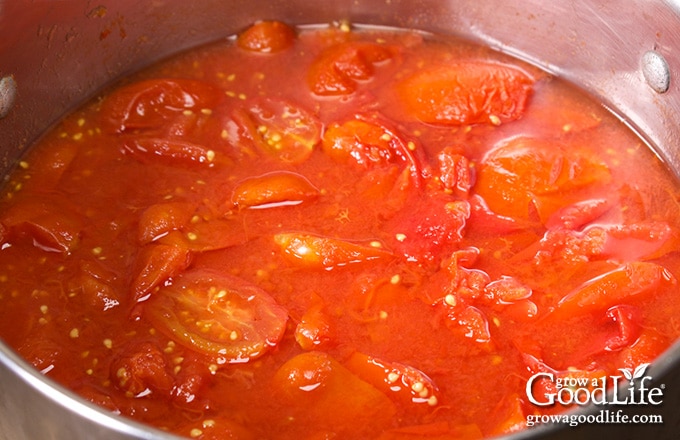 overhead image of a pot of cooked tomatoes on the stove