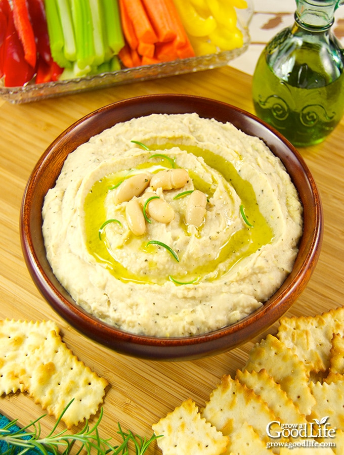 This simple recipe for white bean dip is filled with flavor. Begin with Cannellini beans, add roasted garlic, rosemary, olive oil, and brighten with lemon juice and zest. Puree to a smooth and creamy texture that pairs well with crackers and veggies.