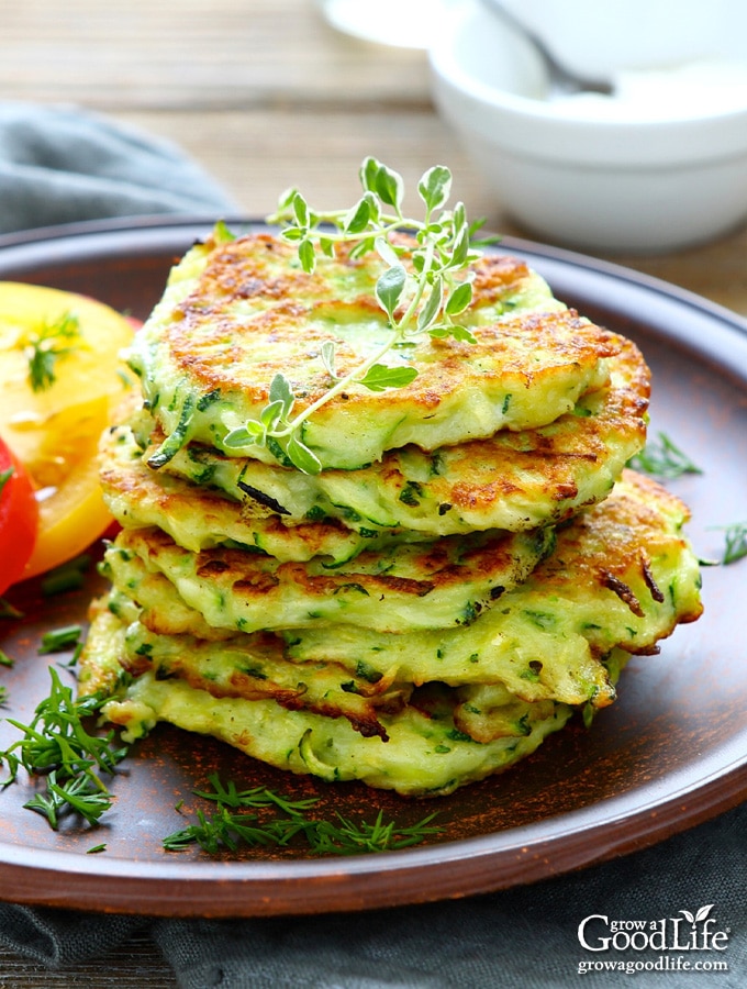 a stack of zucchini fritters on a brown plate