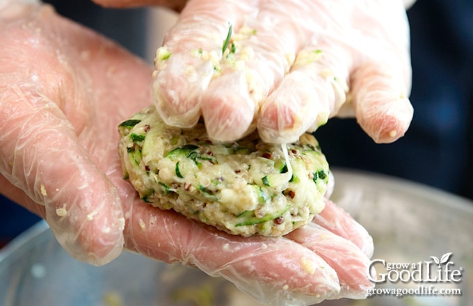 closeup of hands forming zucchini patties