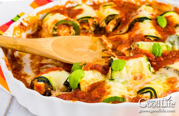 close up of baked cheesy zucchini roll ups casserole on a table