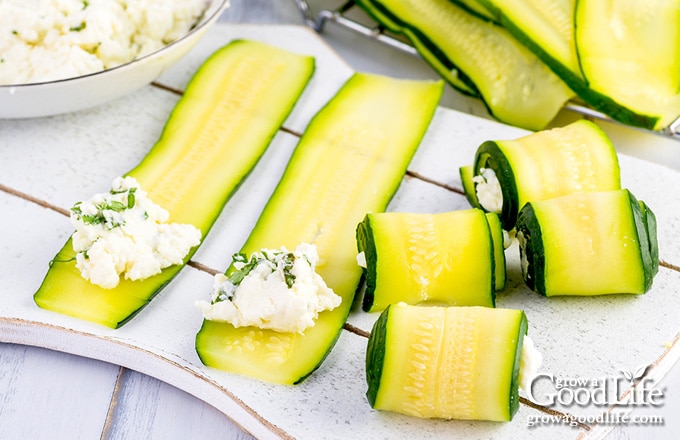 adding cheese and rolling up the zucchini